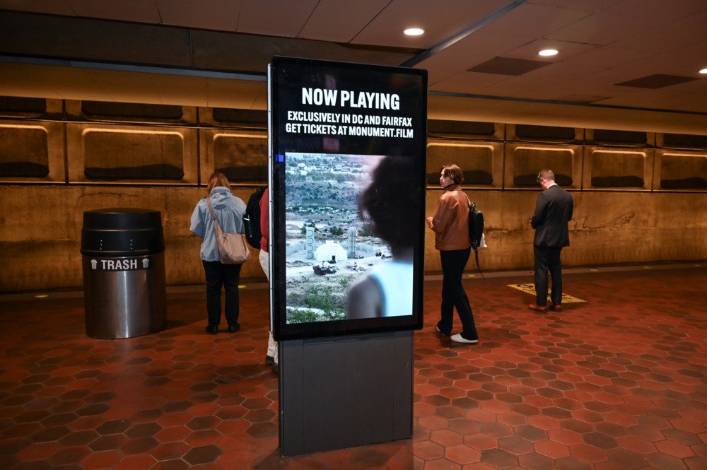 Monument creative on platform with commuters at L'Enfant Plaza station
