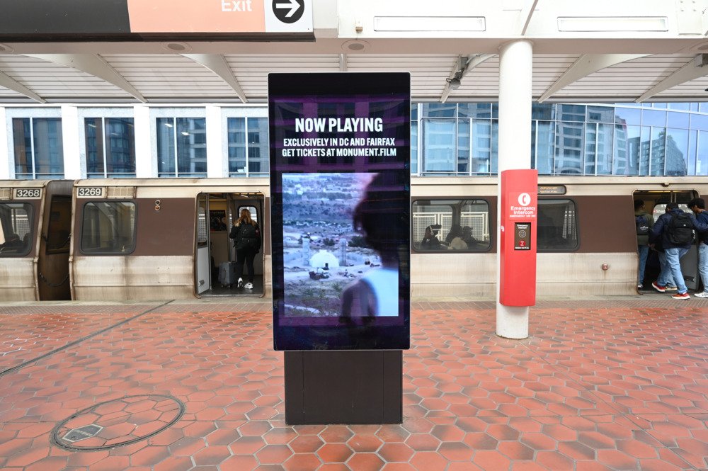 Monument creative on platform with arriving train at DC Metro Rail Platform Network